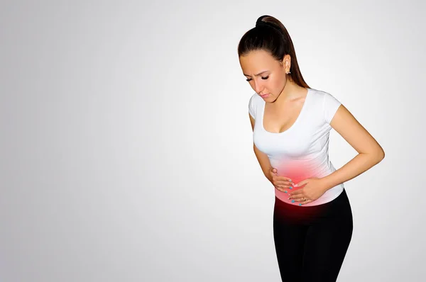 Young woman suffering from backache and flank pain on white background.  Cause of pain include UTI, kidney stones, gallbladder disease or muscle  problems. Health care and medical concept. Stock Photo