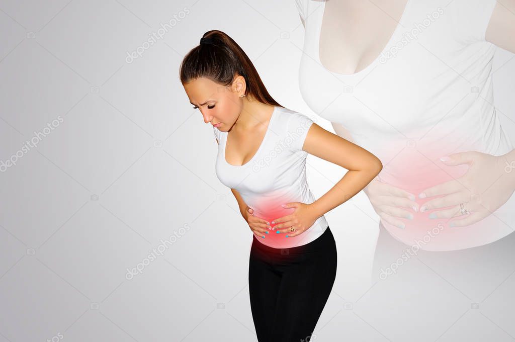 Abdominal pain. A young woman suffers from pain in the abdomen. The problem with digestion. The problem of women's health, the concept of menstruation. A place of pain marked with a red spot. Concept 