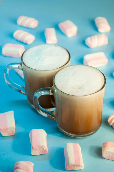 Bevanda calda di Natale Caffè al cacao o cioccolato con crema di latte e marshmallow in una piccola tazza trasparente su sfondo blu. Inverno. Anno nuovo — Foto Stock