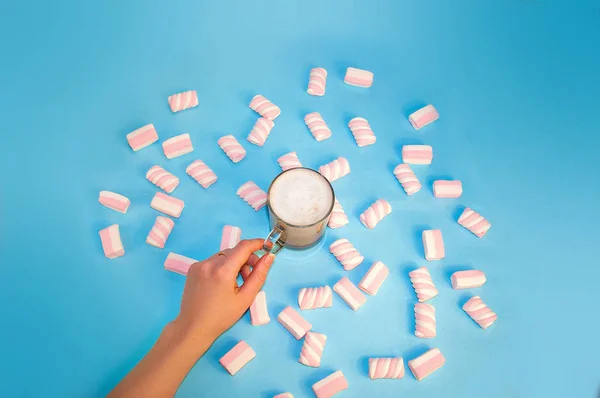 Heißgetränk Kakao oder Schokolade mit Milchcreme und Marshmallows in einer kleinen durchsichtigen Tasse auf blauem Hintergrund. Winter. Neues Jahr — Stockfoto