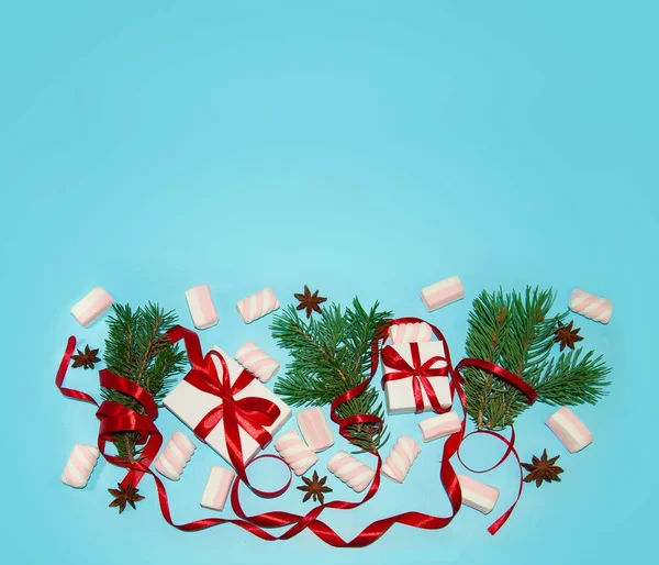 Christmas Holiday samenstelling. Nieuwjaar Gift in witte doos met rood lint Fir Tree takken steranijs Marshmallows op blauwe achtergrond plat lag bovenaanzicht met kopie ruimte voor uw tekst — Stockfoto