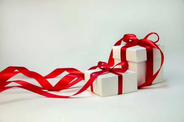 明るい背景に赤いリボンの白いボックスのクリスマス ギフト。新年休日の組成物。テキストのコピー スペース — ストック写真