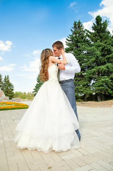 Jour du mariage. Belle mariée en robe blanche avec marié. Couple baisers heureux après le mariage — Photo