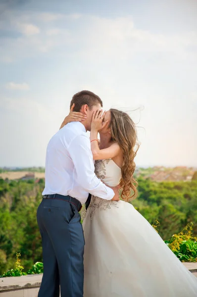 Düğün günü. Güzel gelin damat ile beyaz elbiseli. Mutlu çift öpüşme — Stok fotoğraf