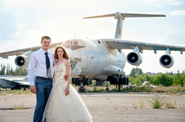 Την ημέρα του γάμου. Ευτυχισμένο ζευγάρι για το φόντο του αεροπλάνου — Φωτογραφία Αρχείου