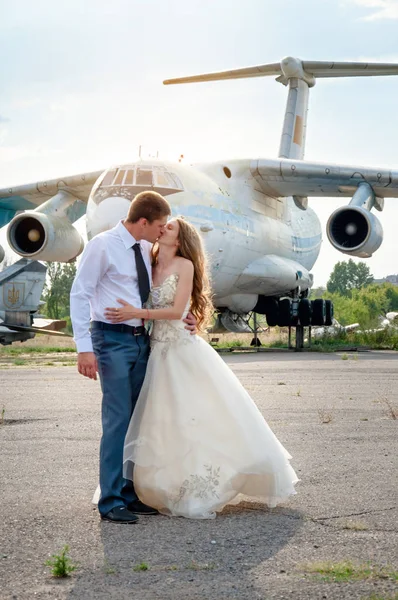 Düğün günü. Uçağın arka planda mutlu öpüşme Çift — Stok fotoğraf
