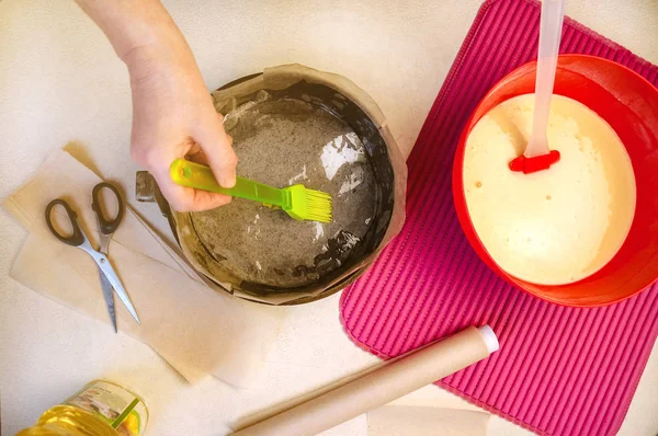 Випічка інгредієнтів і посуду для приготування пирога губки. Жінка змащує олією посуд для випічки. Плоский вигляд зверху . — стокове фото