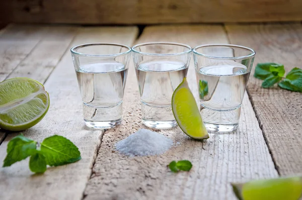 Alcohol Shot Drink. Silver Tequila with Lime, Salt and Green on the Wooden Table — Stock Photo, Image