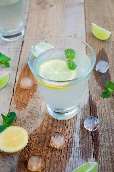 Refreshing Summer Cocktail with Citrus Fruit Ice and Mint on Wooden Table
