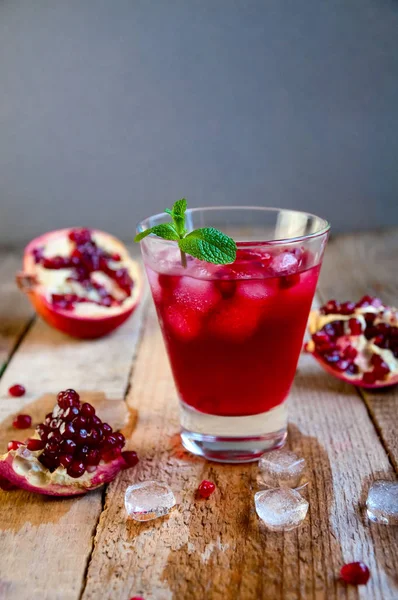 Cóctel de granada con menta helada y fruta en mesa de madera. RED —  Fotos de Stock