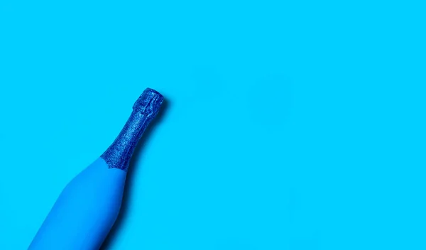 Festliche minimalistische Champagnerflasche auf blauem Hintergrund. kreatives Konzept. klassisches Blau - Farbe des Jahres 2020. — Stockfoto