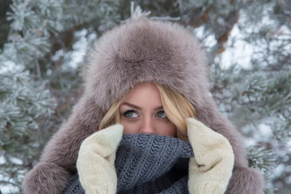 Winterportret van een mooie glimlachende vrouw met sneeuwvlokken in witte vachten — Stockfoto