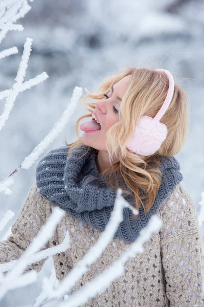 Mooi meisje in roze koptelefoon op de sjaal met sneeuw — Stockfoto