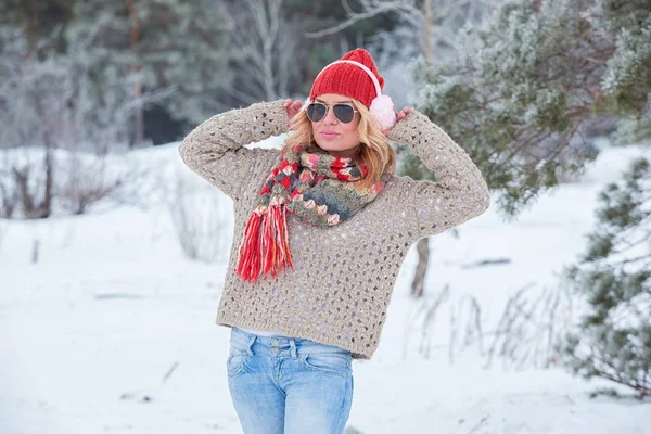 Красивая девушка в красной шляпе и свитер в снегу в розовом с наушниками и шарфом — стоковое фото