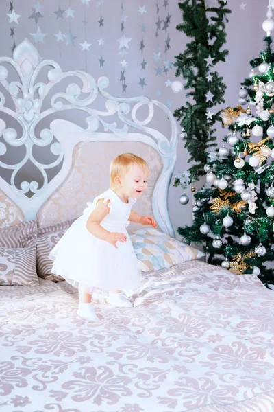 クリスマスに白いドレスで幸せな少女は、部屋を飾った — ストック写真