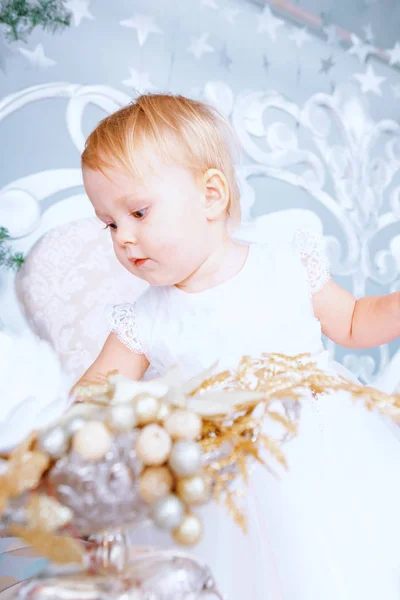 白いドレスで幸せな女の子クリスマス装飾の部屋にツリーを飾る — ストック写真