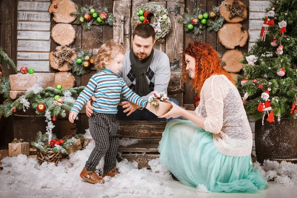 Navidad feliz familia de tres personas y abeto con cajas de regalo año nuevo fondo decorado invierno — Foto de Stock