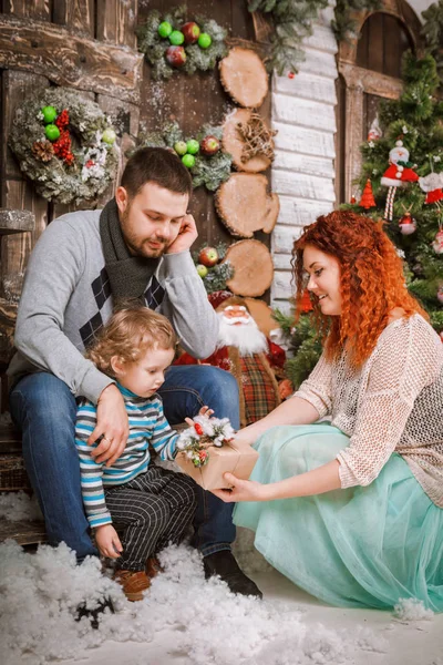 Navidad feliz familia de tres personas y abeto con cajas de regalo año nuevo fondo decorado invierno — Foto de Stock