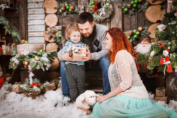 Navidad feliz familia de tres personas y abeto con cajas de regalo año nuevo fondo decorado invierno — Foto de Stock