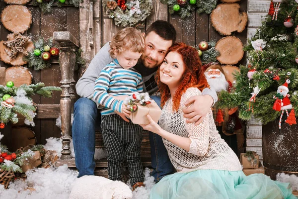 Navidad feliz familia de tres personas y abeto con cajas de regalo año nuevo fondo decorado invierno — Foto de Stock
