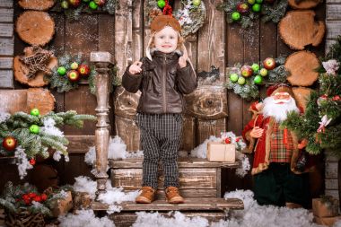 Braun deri ceket, pantolon ve bot üzerinde Noel süslemeleri poz pilot şapkası ile küçük iki yaşında bir çocuk giymiş