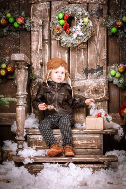 Braun deri ceket, pantolon ve bot üzerinde Noel süslemeleri poz pilot şapkası ile küçük iki yaşında bir çocuk giymiş