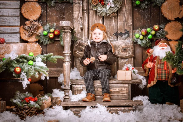 Braun deri ceket, pantolon ve bot üzerinde Noel süslemeleri poz pilot şapkası ile küçük iki yaşında bir çocuk giymiş