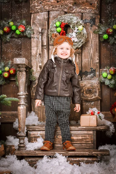 Braun deri ceket, pantolon ve bot üzerinde Noel süslemeleri poz pilot şapkası ile küçük iki yaşında bir çocuk giymiş