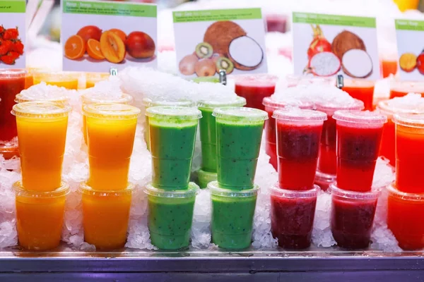 Una variedad de coloridas y afrutadas bebidas sobre hielo en un mercado de Barcelona, España —  Fotos de Stock