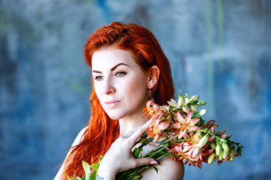 Büyüleyici romantik kadın kadın Gloriosa turuncu mavi arka plan üzerinde tutar.