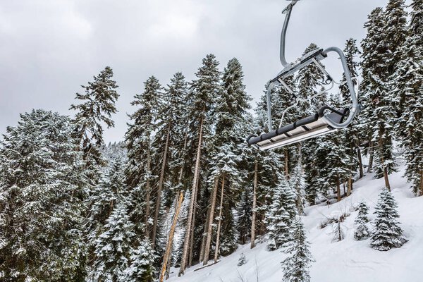 View from Hatsvali Khatsvali ski resort cableway in winter. Cables, snow in the forest and mountain Ushba. Mestia, Georgia