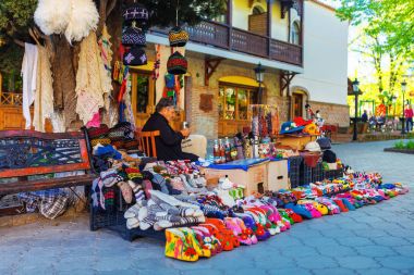 Signagi, Gürcistan - 20 Nisan, 2017: kadın kadın satıcı satan ve yün terlikler dokuma kumaşlar ve Sighnaghi veya Signagi şehir, Bölge: Kakheti, Georgia sokakta veya parlak Hatıra çorap