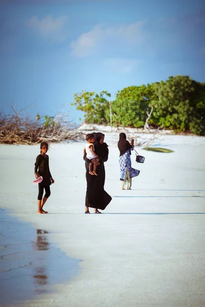 Мусульманських жінок і дітей ходьбі на пляжі невелике село Острів — стокове фото