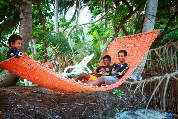 Los niños están descansando en hammovk en la playa del pequeño pueblo de la isla —  Fotos de Stock