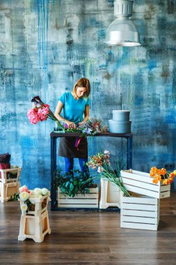 Büyüleyici neşeli kadın Dükkanı ortanca mor çiçekler ve kutuları ile çevrili ile renkli Pembe buket Yapım Yardımcısı