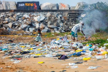 Kız çocuk çöp yığınları içinde şilep ile adaya annesi beach, Kollam üzerinde Kerala yanıyor