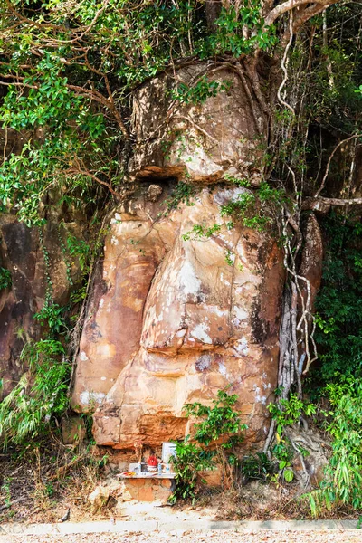 Rosto de pedra de Buda pela estrada pitoresca em montanhas do parque nacional Bokor levando ao hotel abandonado Bokor Palace na estação Ghost town Hill perto de Kampot. Camboja — Fotografia de Stock