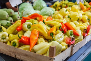 green yellow orange red bell pepper paprika on a farmer's market clipart