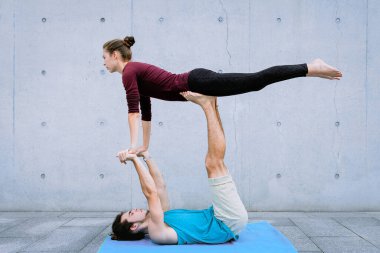Dışarıda akro yoga yapan bir çift. Akroyoga konsepti. Ön kuş pozu. Yeni başlayanlar için Asana