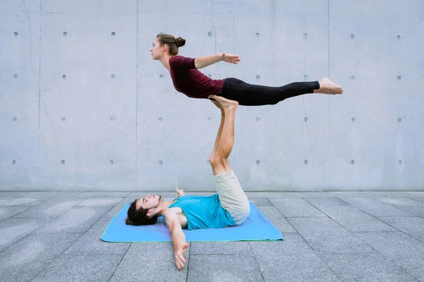 Couple practicing acro yoga outdoors. Acroyoga concept. Front Bird pose — Stock Photo, Image
