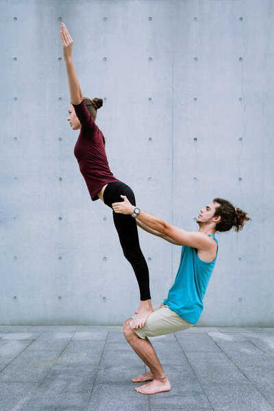 Couple practicing acro yoga outdoors. Acroyoga concept.