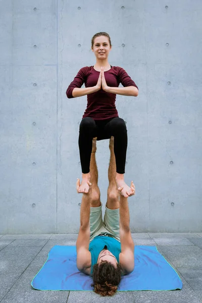 Pareja practicando acro yoga al aire libre. Concepto de acroyoga. Postura del trono — Foto de Stock