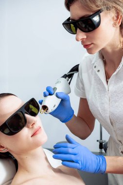 Cilt bakımı. Genç Kadın Kozmetik Kliniğinde Yüze Güzellik Tedavisi Alınıyor, Pigmentasyonu Kaldırıyor. Yoğun Nabız Işık Terapisi. IPL. Yenilenme, Fotoğraf Yüz Terapisi. Yaşlanma önleme prosedürleri.