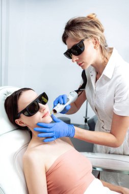 Cilt bakımı. Genç Kadın Kozmetik Kliniğinde Yüze Güzellik Tedavisi Alınıyor, Pigmentasyonu Kaldırıyor. Yoğun Nabız Işık Terapisi. IPL. Yenilenme, Fotoğraf Yüz Terapisi. Yaşlanma önleme prosedürleri.