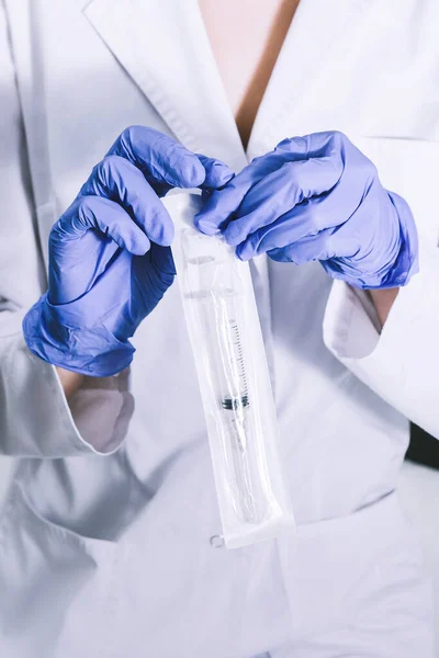 Equipo de medicina estéril. Doctor con guantes azules estériles que abren la jeringa de agujas médicas estériles.. Fotos De Stock Sin Royalties Gratis