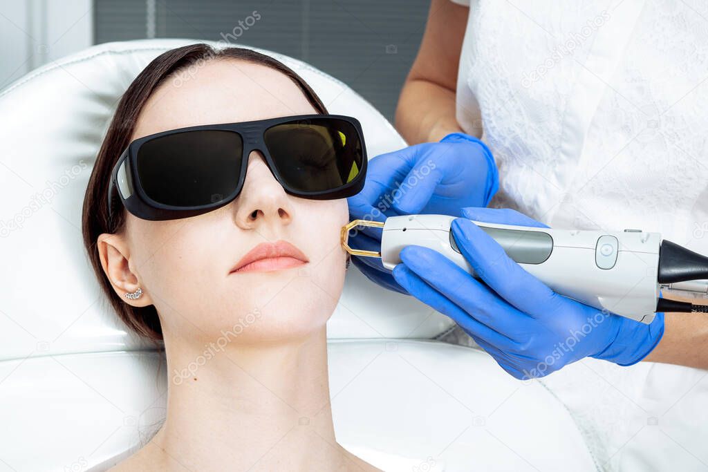Woman Receiving Facial Beauty Treatment, Removing Pigmentation photo Intense Pulsed Light Therapy. IPL. Anti-aging