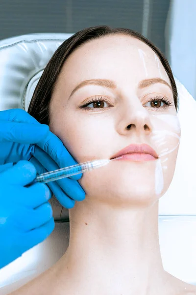 Médico cosmetólogo hace Rejuvenecer relleno botulinum inyecciones faciales procedimiento en la piel femenina en salón de belleza — Foto de Stock