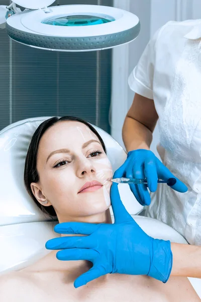 Médico cosmetólogo hace que el rejuvenecimiento Biorevitalization inyecciones faciales procedimiento en la piel femenina en el salón de belleza — Foto de Stock