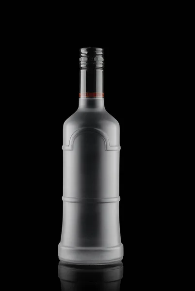 Frosted glass bottle, with alcohol, on black background — Stock Photo, Image