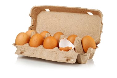 Beyaz arka planda karton bir kutuda çiğ kahverengi tavuk yumurtası..